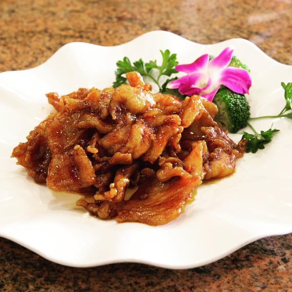 Monark Asian Bistro's sweet and sour pork, garnished with broccoli, parsley, and an orchid.