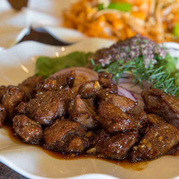 Close-up of Monark Asian Bistro's Chinese pepper steak with onions and herbs.